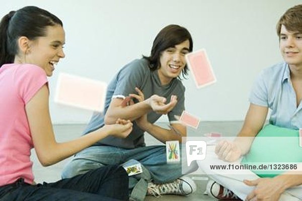 Teenager-Freunde werfen Spielkarten in die Luft