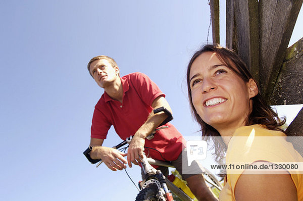 Couple having a rest  woman leaning on wooden railing