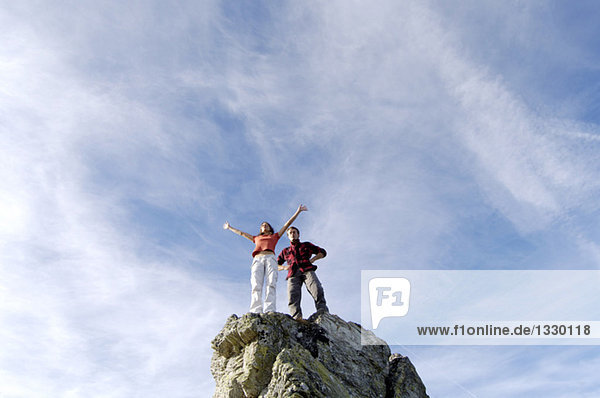 Junges Paar auf Berggipfel stehend,  Tiefblick