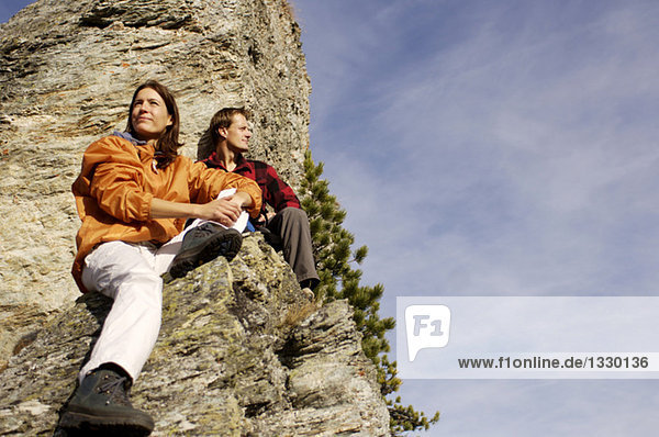 Junges Paar entspannt auf dem Berggipfel,  Tiefblick