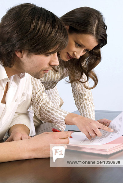 Businessman and woman looking at documents  side view  close-up