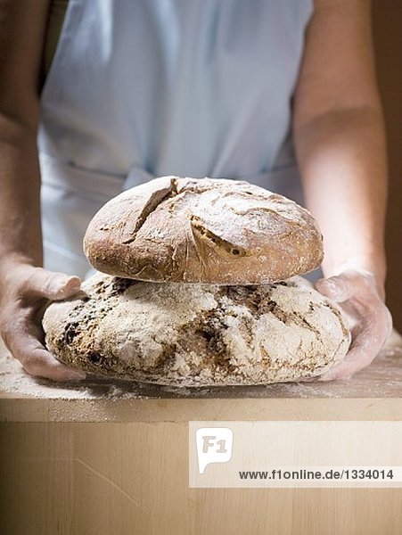 Frau hält zwei Laibe Bauernbrot