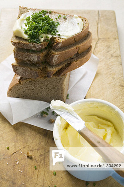 Mehrere Brotscheiben gestapelt mit Butter und Schnittlauch Mehrere Brotscheiben gestapelt mit Butter und Schnittlauch