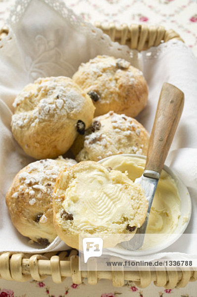 Gezuckerte Rosinenbrötchen mit Butter im Brotkorb Gezuckerte Rosinenbrötchen mit Butter im Brotkorb