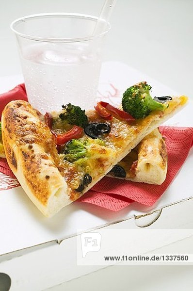 Zwei Stücke Gemüsepizza (amerikanische Art) und Mineralwasser
