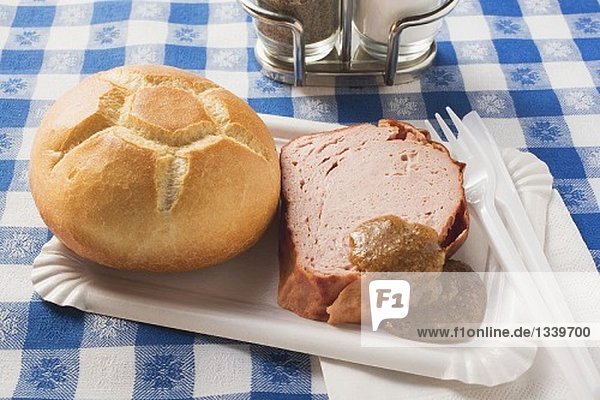 Leberkäse mit Brötchen und Senf auf Pappteller