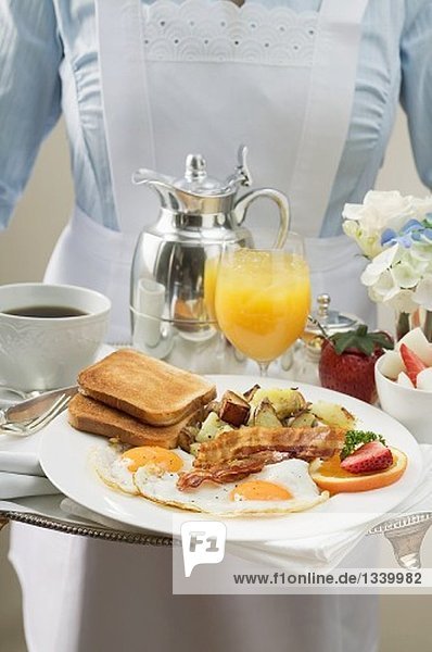 Chambermaid serving breakfast tray
