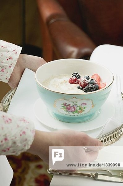 Hände servieren Tablett mit Porridge