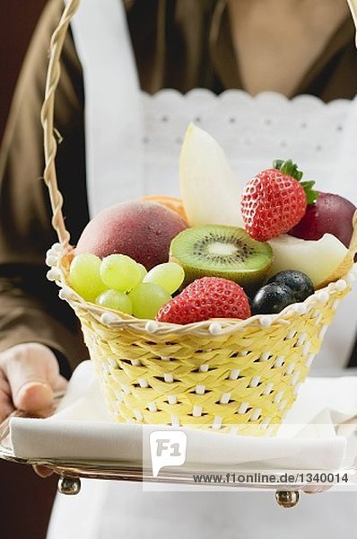 Waitress serving a basket of fruit