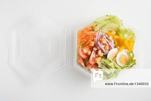 Eissalat mit Schinken  Käse  Ei und Gemüse in Plastikschale