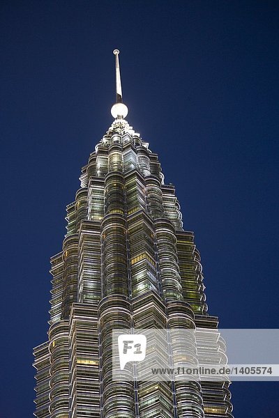 High section view of skyscrapers lit up against clear blue sky  Petronas Towers  Kuala Lumpur  Malaysia
