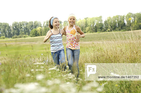 Two girls running in field
