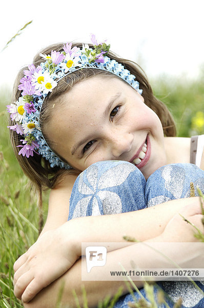 Porträt des Mädchens im Feld sitzt und lächelnd