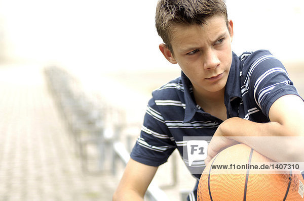 Nahaufnahme der Teenager suchen ernsthaft und hält basketball