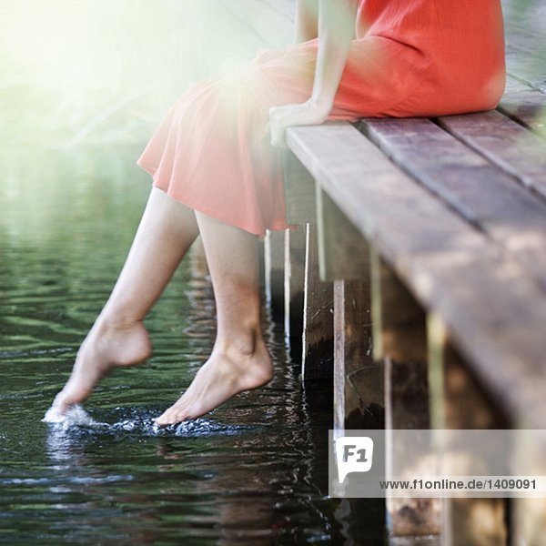 Junge Frau sitzend von einem Fluss