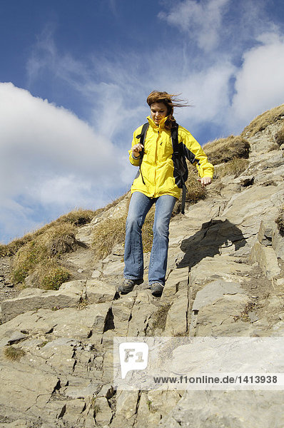 Low angle view of woman hiking on rocky mountain  Bregenzer Wald  Vorarlberg  Austria