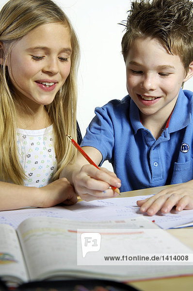 Close-up of brother and sister studying and smiling