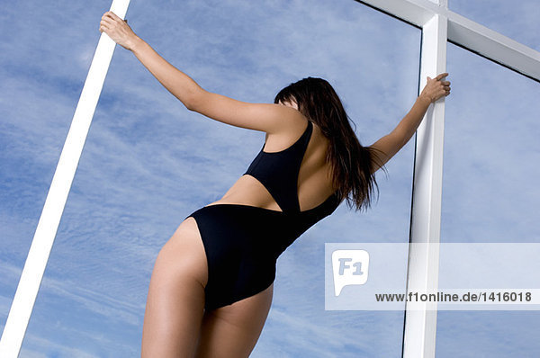 Junge Frau in schwarzem sexy Badeanzug  Rückansicht
