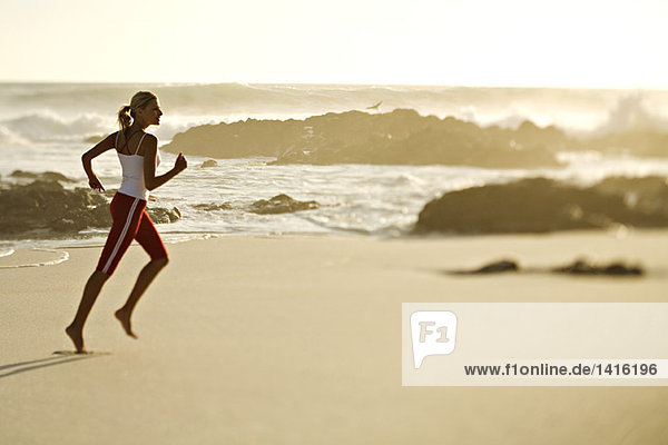 Junge Frau  die am Strand rennt