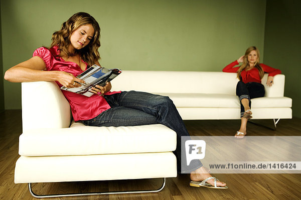 2 Frauen beim Lesen auf dem Sofa