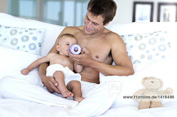 Father feeding his baby  indoors