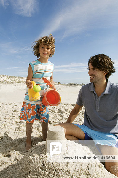 Vater und Sohn spielen am Strand  im Freien