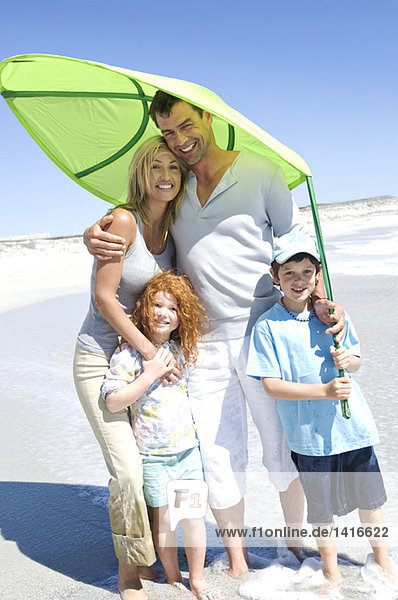 Parents and two children on the beach  posing for the camera  outdoors