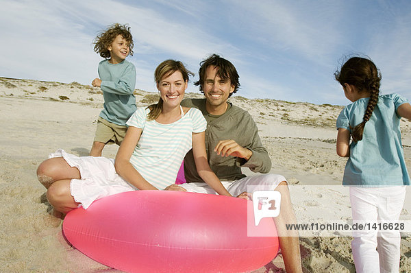 Eltern und zwei Kinder am Strand  Paar posiert für die Kamera  im Freien