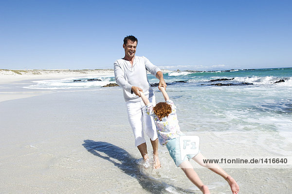 Father playing with daughter on the beach  outdoors