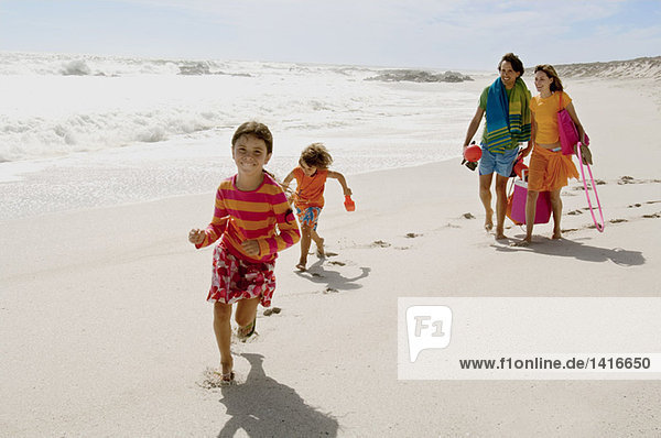 Parents and two children walking on the beach  outdoors