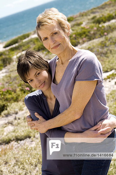 Seniorin und erwachsene Tochter umarmend  draußen