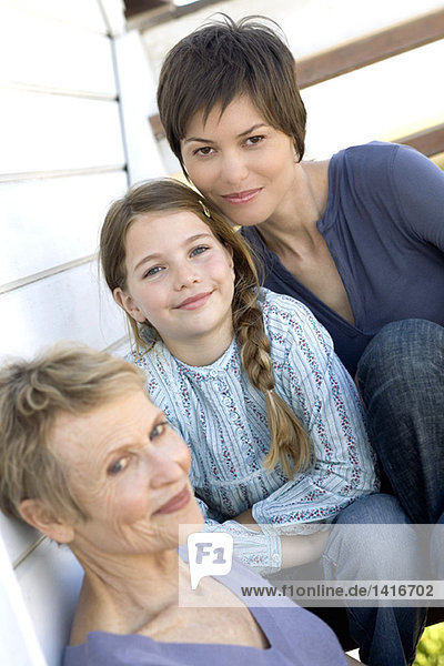Female members of three generation family looking at camera  outdoors