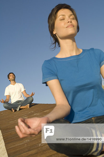 Young couple in yoga attitude  outdoors