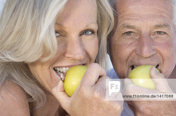 Portrait of smiling couple eating apples