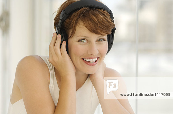 Porträt einer jungen Frau  Musik hören über Kopfhörer