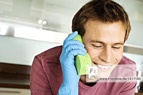 Portrait of a man making a phone call with a sponge