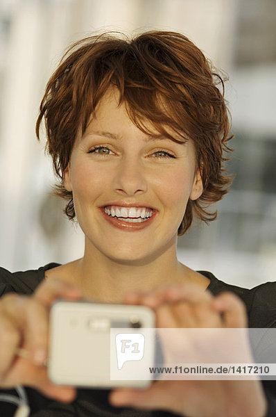 Porträt einer jungen Frau mit Digitalkamera