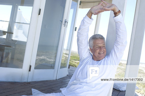 Man stretching on wooden terrace
