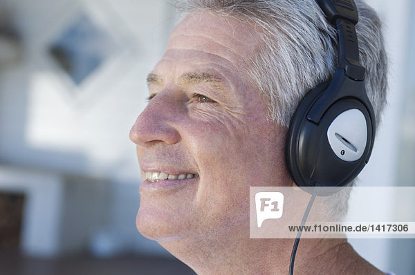Portrait of smiling man listening to music with headphones