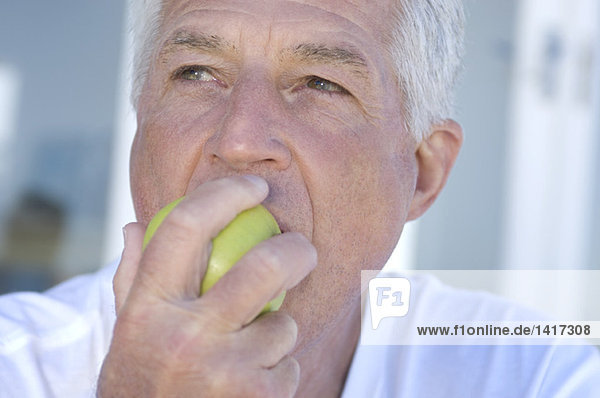 Porträt eines Mannes  der einen Apfel isst