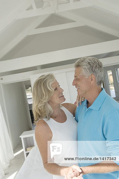 Smiling couple embracing in bedroom