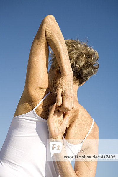 Senior woman stretching  rear view