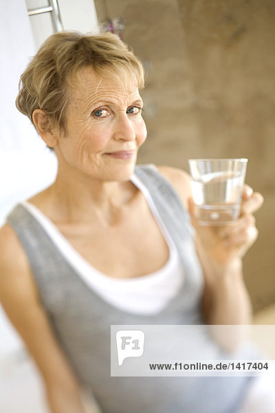 Seniorenfrau mit einem Glas Wasser