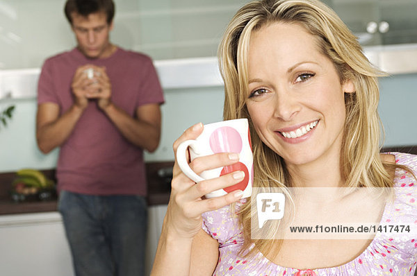 Couple holding mugs in kitchen