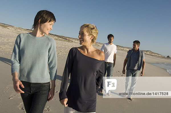 2 couples walking on the beach