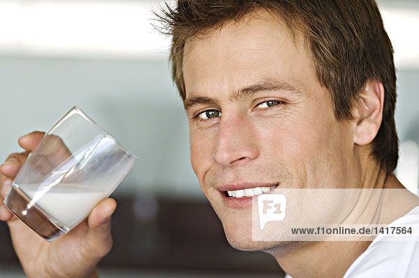 Porträt eines jungen Mannes  der Milch trinkt