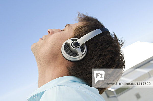 Portrait of young man listening to music with headphones