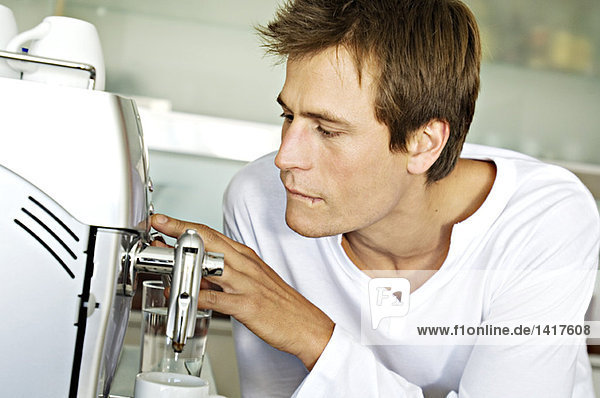 Junger Mann mit Espressomaschine