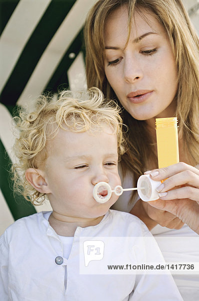 Mother and son blowing soap bubbles
