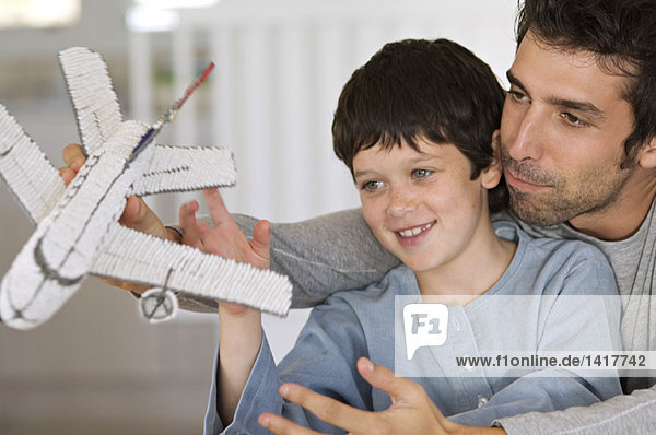 Father and son playing with model aeroplane